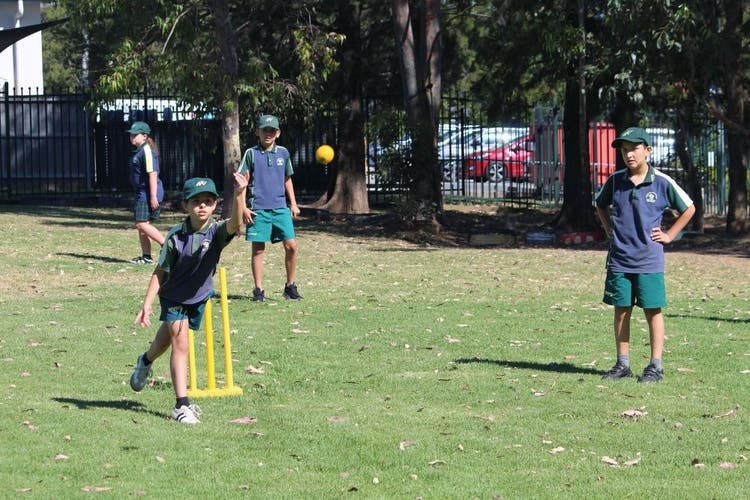 students playing cricket on the oval