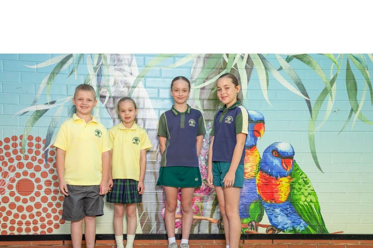 Students standing in front of school art wall