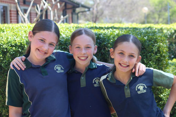 3 girls smiling arms around each other